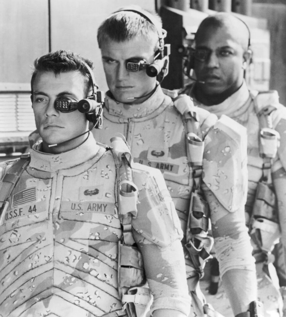 Three U.S. Army soldiers in camouflage uniforms wearing head-mounted night-vision gear and radios, posing together in a line.