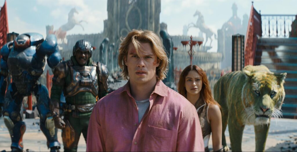 Man in a pink shirt walks toward the camera with armored troops and a lion-like creature behind him in a fantasy cityscape.