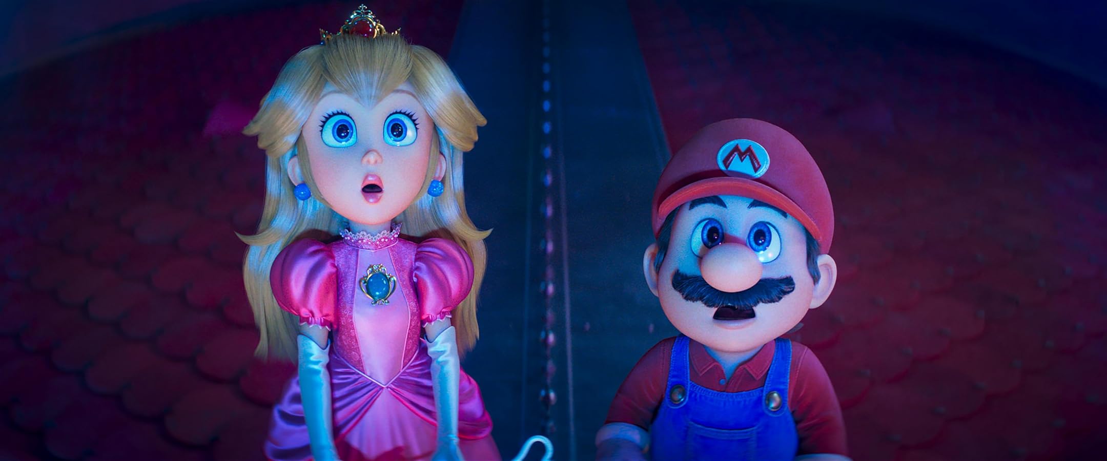 Two life-sized Mario and Princess Peach action figures stand side by side in a dim blue-lit scene, both with surprised expressions.