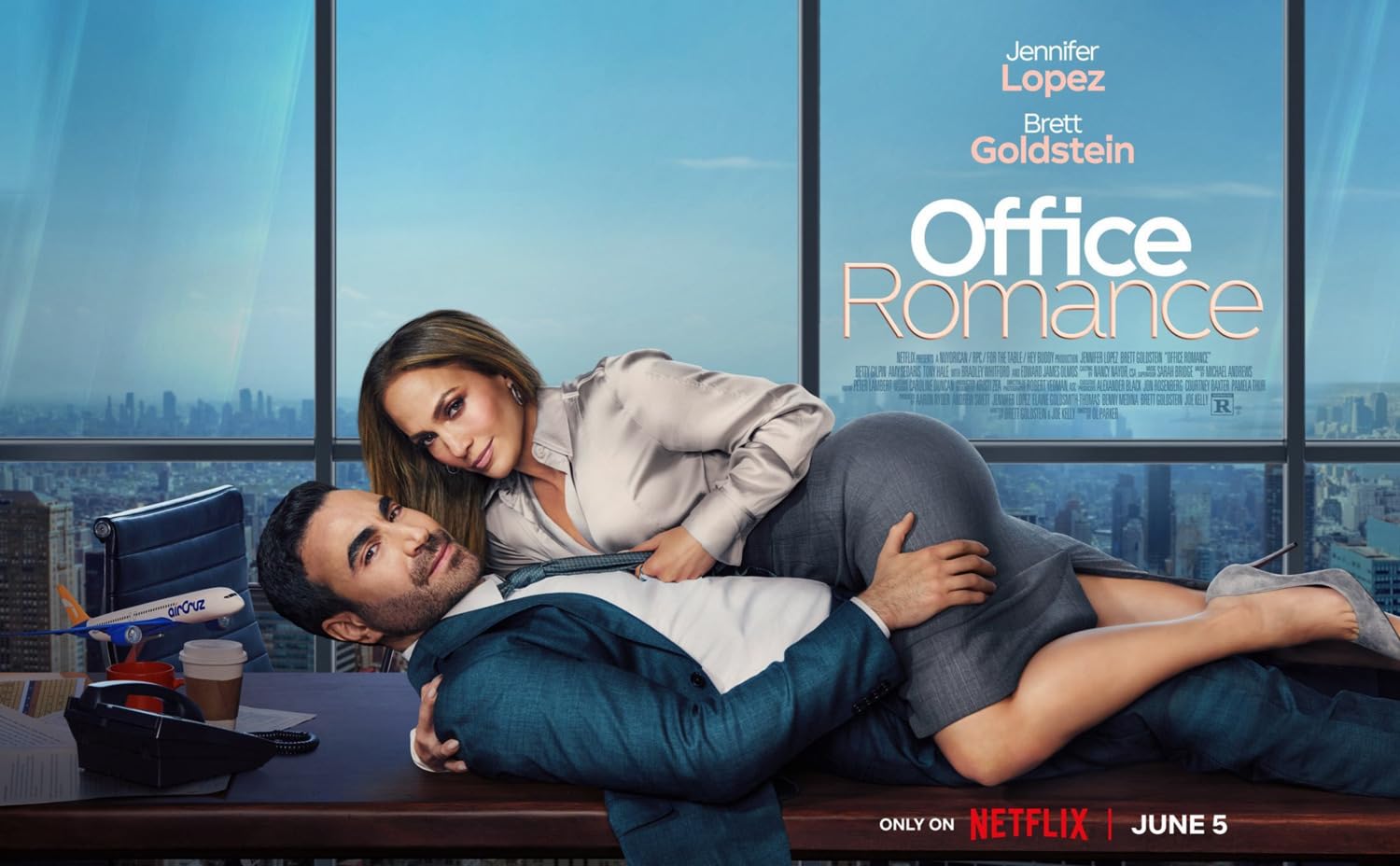 Promotional poster for Office Romance: a man in a suit lies on a desk as a woman straddles him, with a city skyline background.
