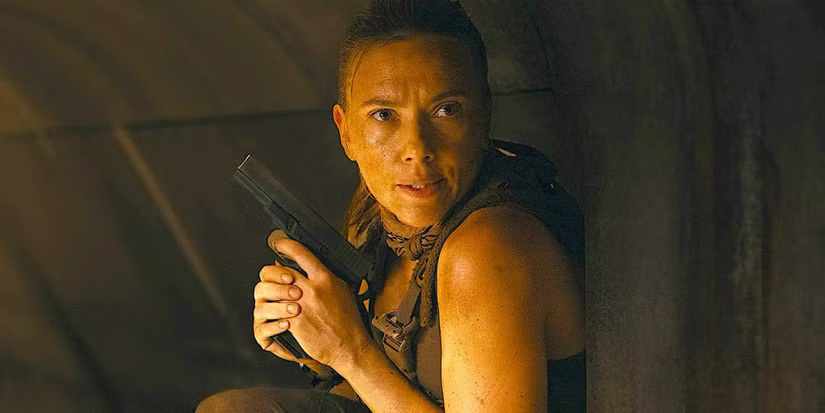 A woman in a sleeveless outfit crouches in a dim tunnel, gripping a handgun with a focused expression.