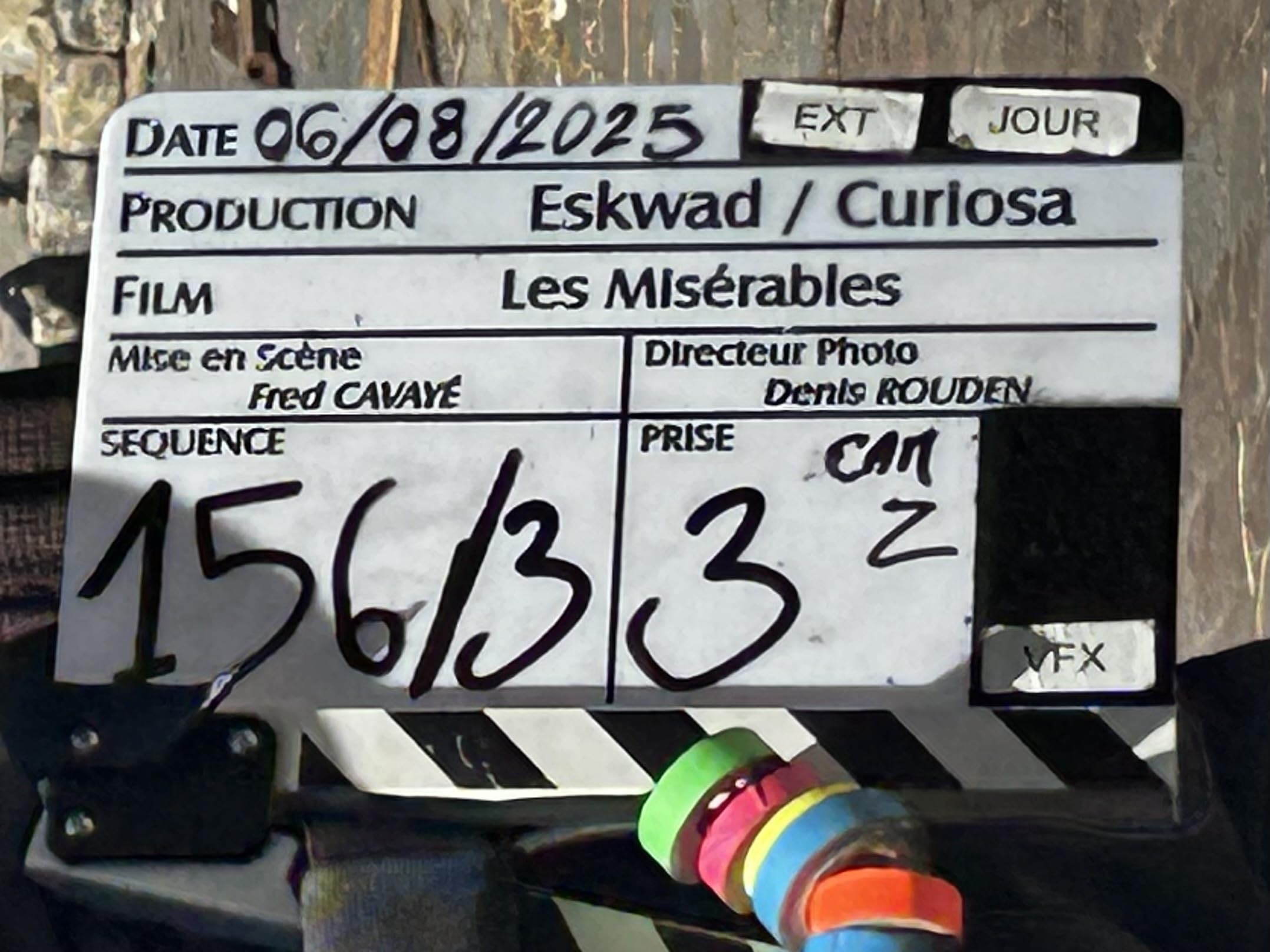 Clapboard with production details: Production Eskwad/Curiosa, Film Les Misérables, Date 06/08/2025, EXT scene, DP Denis Rouden, Director Fred Cavayé